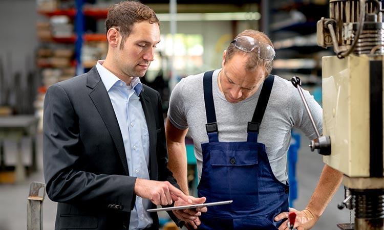 Veiligheidstechnicus en werknemer die een controle verrichten
